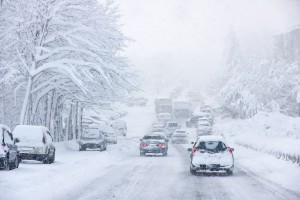 Image of traffic struggling through snow and ice in freezing winter weather, slick, snowy roads.