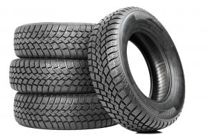 image - Stack of three tires, fourth tire leaning against stack