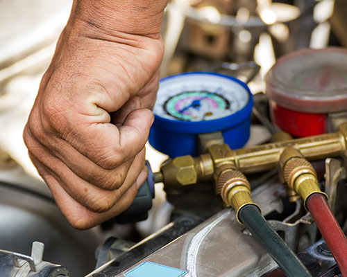 AAMCO Minnesota Tech Showing a Customer Under The Hood Of Her Car