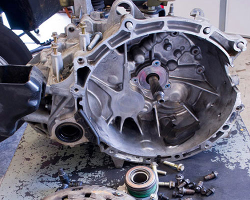 AAMCO Minnesota Tech Showing a Customer Under The Hood Of Her Car