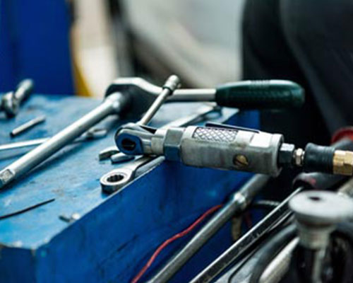 AAMCO Minnesota Tech Showing a Customer Under The Hood Of Her Car