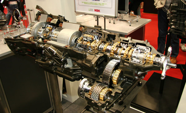 AAMCO Minnesota Tech Showing a Customer Under The Hood Of Her Car